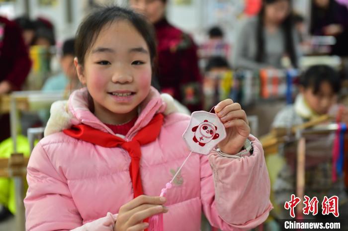 圖為一名小學(xué)生繡制的2022年北京冬奧會(huì)吉祥物“冰墩墩”形象。　喻云亮 攝