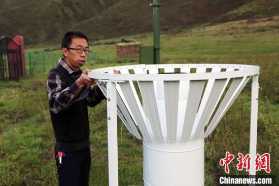 圖為班瑪縣氣象局工作人員在維護藏雪茶基地氣候站。青海省氣象局供圖