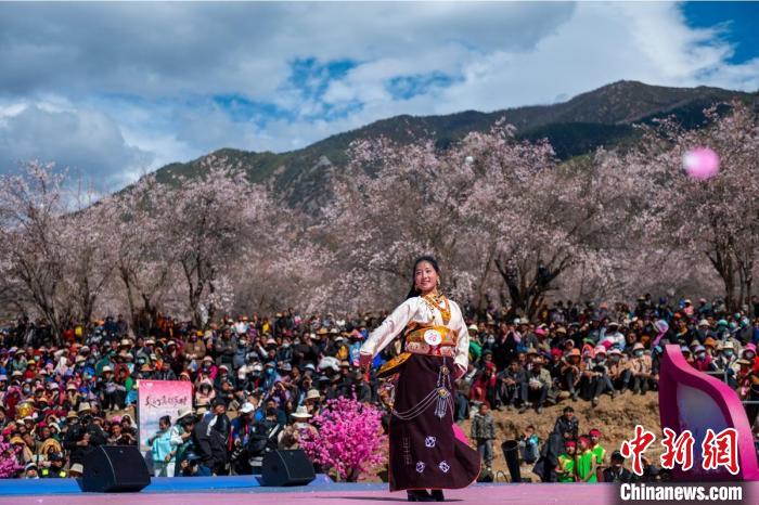 桃花林下精彩的“桃花仙子”選拔吸引村民或游客。　劉忠俊 攝