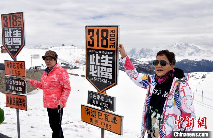 圖為5月14日，西藏林芝色季拉山觀景臺，游客與南迦巴瓦峰合影?！±盍?攝