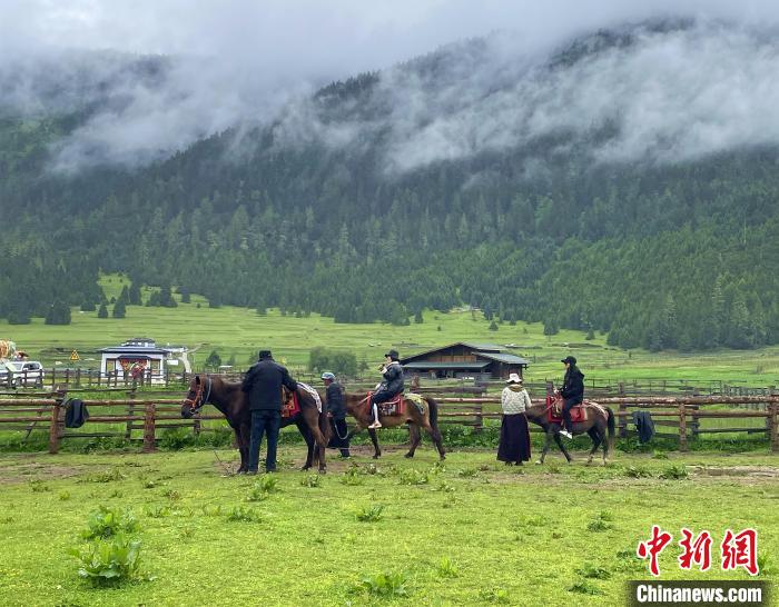 6月10日，游客在魯朗小鎮高山牧場景區體驗騎馬。　冉文娟 攝