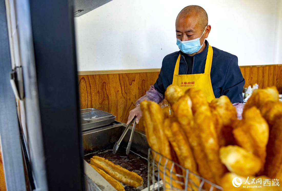 早餐店老板正在炸油條。人民網 次仁羅布攝