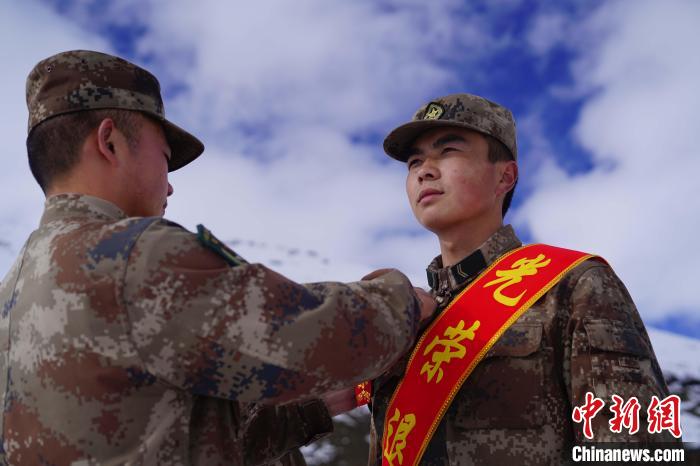 排長王朝偉(圖左)給退伍老兵佩戴大紅花。　西藏山南軍分區某團供圖